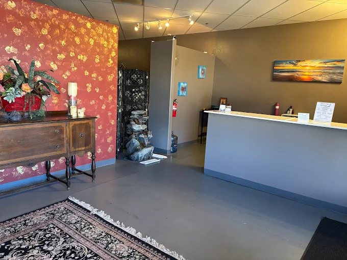 The Desert Zen front desk and lobby, with a carved wooden sideboard and fresh flowers by the entrance